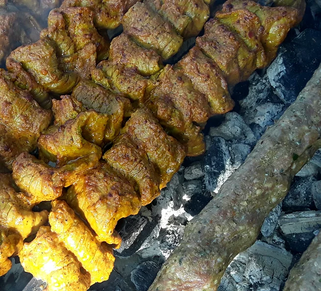 Chicken tikka and seekh kabab skewers over charcoal