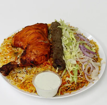 Biryani rice plate with tandoori chicken, a seekh kabab, salad and raita