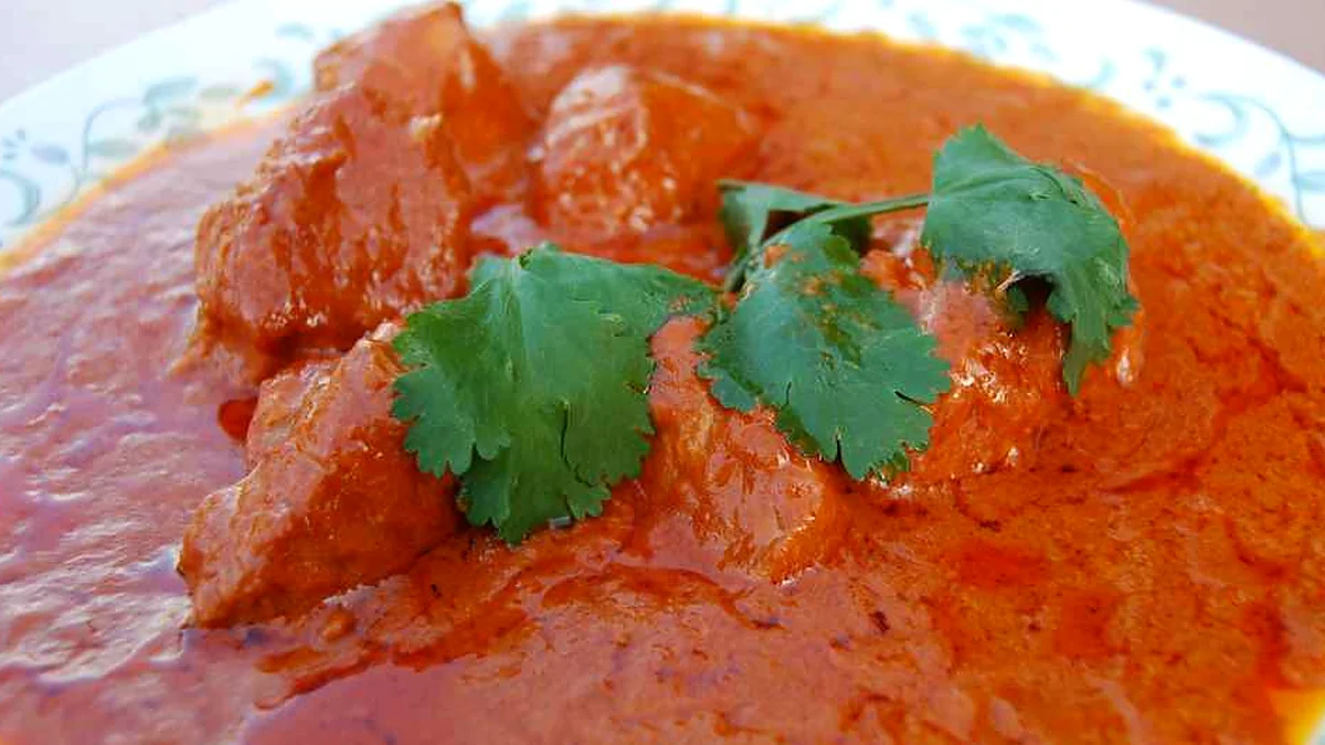 Butter chicken: boneless chicken pieces in an orange butter sauce topped with fresh coriander