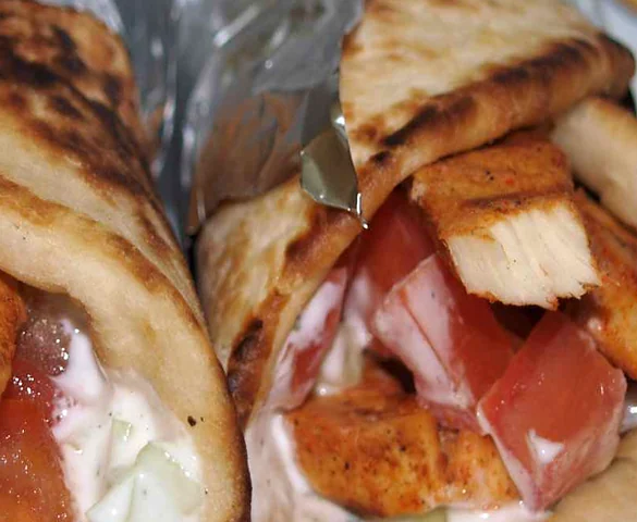 Chicken tikka rolls: spiced chicken pieces, tomato and white sauce wrapped in grilled flatbread